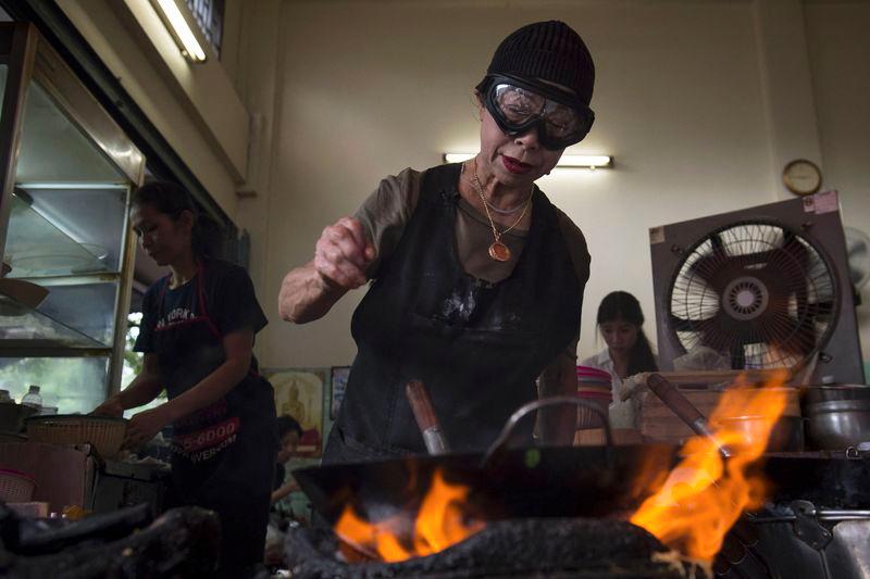 Jay Fai puts seafood in a frying pan whilst cooking in her restaurant, a day after her street-side eatery was recognised with a one-star Michelin guide, in Bangkok on December 7, 2017. - AFPPIX