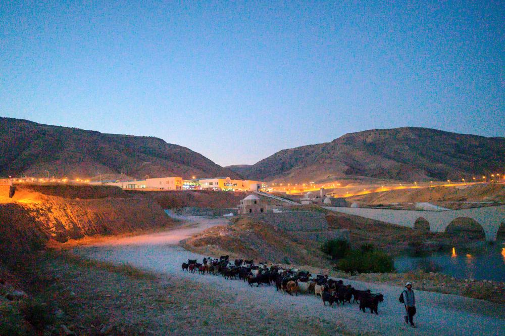 $!(FILES) In this file photo taken on August 3, 2020 a shepherd walks his flock away fron the newly constructed Hasankeyf town, part of the Ilosu Dam project located along the Tigris River in the Batman Province in southeastern Turkey. / AFP / BULENT KILIC