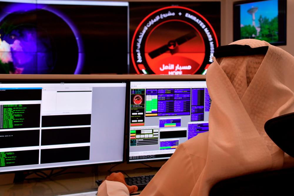 In this file photo taken on July 05, 2020 an employee works at the control room of the Mars Mission at the Mohammed Bin Rashid Space Centre (MBRSC), in the Gulf city of Dubai. The oil-rich United Arab Emirates has built a nuclear power programme and sent a man to space, and now plans to join another elite club by sending a probe to Mars. / AFP / GIUSEPPE CACACE