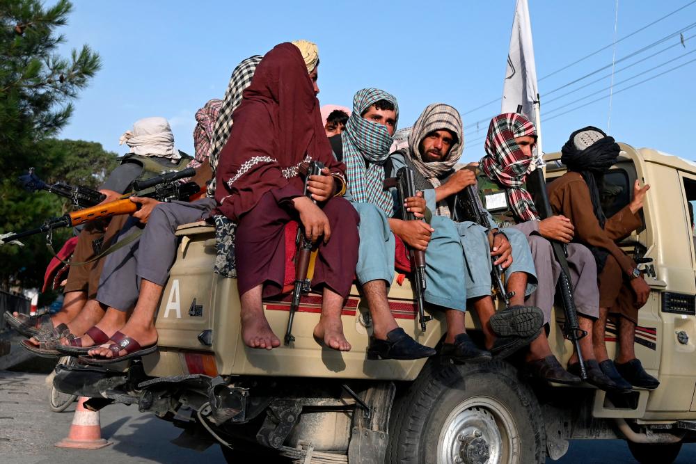 (FILES) In this file photo taken on August 23, 2021 Taliban fighters in a vehicle patrol the streets of Kabul as in the capital, the Taliban have enforced some sense of calm in a city long marred by violent crime, with their armed forces patrolling the streets and manning checkpoints. -AFP