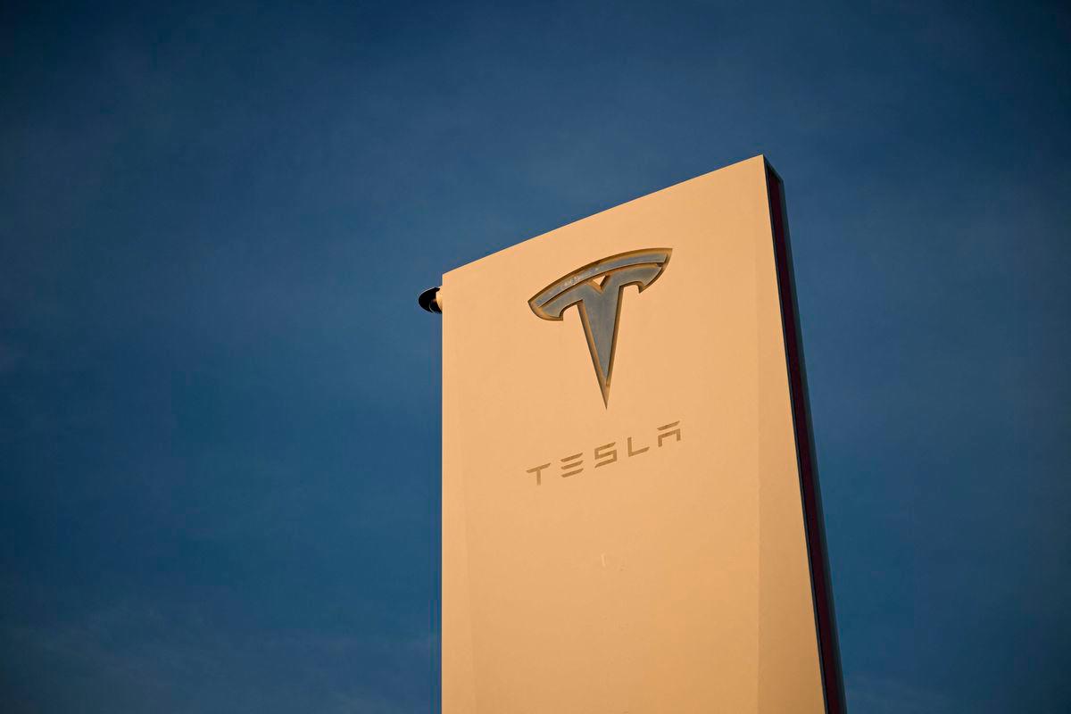 The Tesla, Inc. logo is displayed on a sign outside the Tesla Design Center in Hawthorne, California - AFPPix