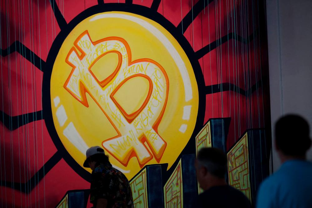 (FILES) In this file photo taken on June 4, 2021 a banner (designed by artists Stacey Coon, Anastasia Sultzer, and Nanu Berk) with the logo of bitcoin is seen during the crypto-currency conference Bitcoin 2021 Convention at the Mana Convention Center in Miami, Florida. – AFP