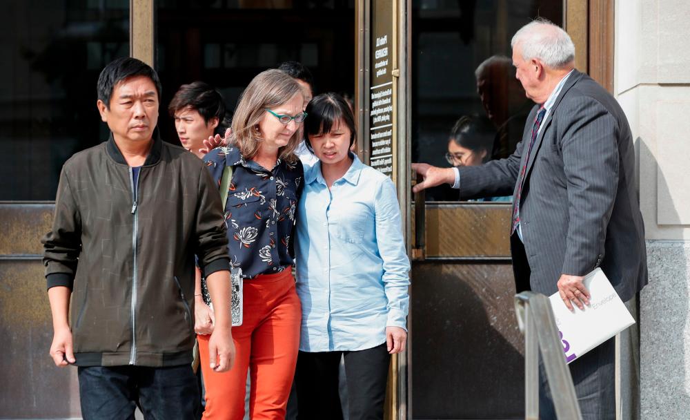 In this file photo taken on July 08, 2019 father Ronggao Zhang (L), and mother Lifeng Ye (2R) of Yingying Zhang leave the US Courthouse after the first day of sentencing of Brendt Christensen in the 2017 disappearance and killing of Yingying Zhang, a visiting scholar from China whose body has not been found, in Peoria, Illinois. — AFP