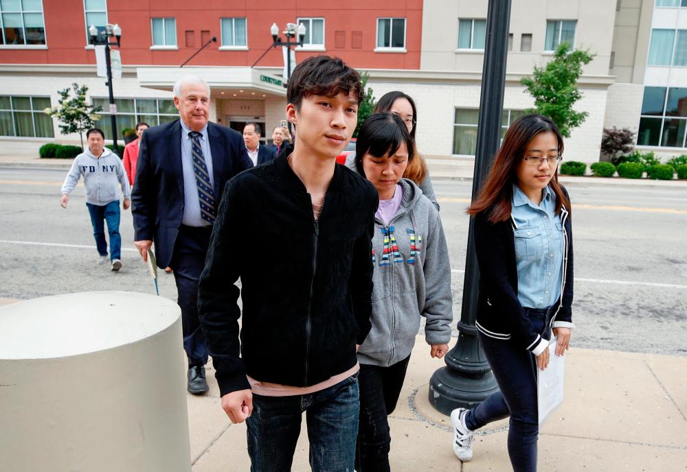 Zhang Yingying’s mother Lifeng Ye (2ndR) and brother Zhengyang Zhang (C) of Yingying Zhang arrive at the US Courthouse as federal trial of Brendt Christensen begins in the 2017 disappearance and suspected killing of Yingying Zhang, a visiting scholar from China whose body has not been found in Peoria, Illinois. — AFP