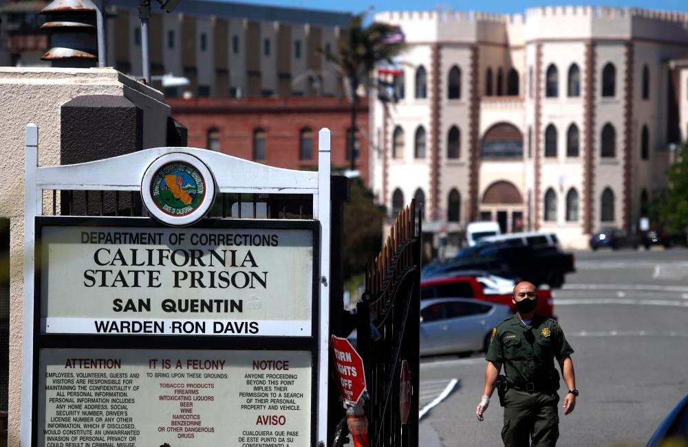 In this file photo a California Department of Corrections and Rehabilitation (CDCR) officer wears a protective mask as he stands guard at the front gate of San Quentin State Prison on June 29, 2020 in San Quentin, California. — AFP