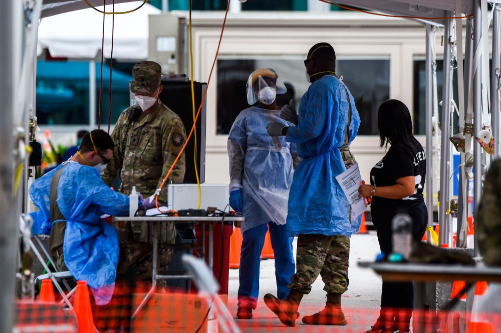 In this file photo taken on July 22, 2020 medical personnel conduct coronavirus testing at a “walk-in” and “drive-through” site in Miami Beach, Florida. — AFP