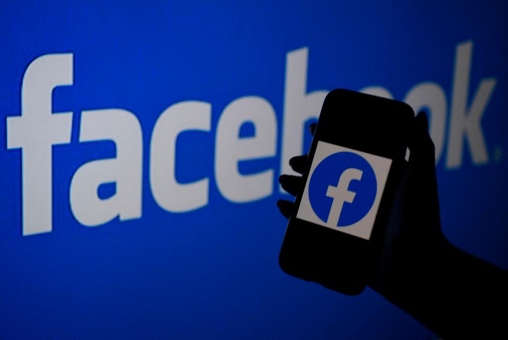 (FILES) In this file photo illustration, a smart phone screen displays the logo of Facebook on a Facebook website background, on April 7, 2021, in Arlington, Virginia. – AFP