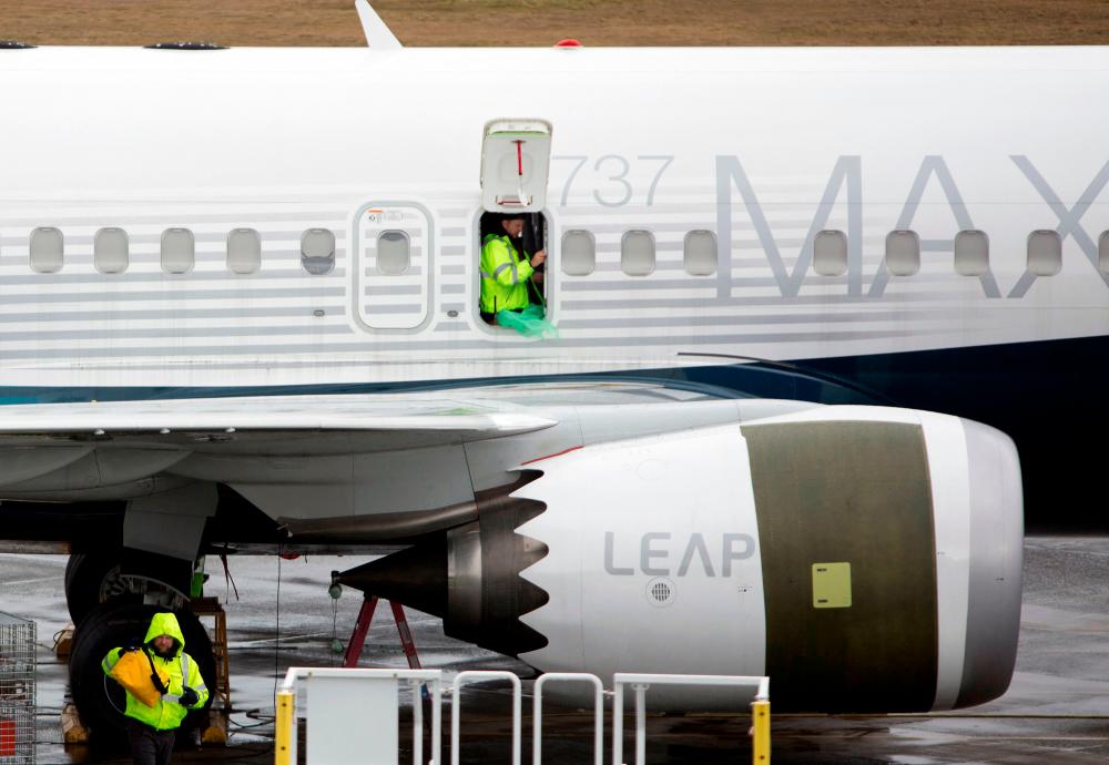 In this file photo taken on March 12, 2019, workers are pictured next to a Boeing 737 MAX 9 airplane on the tarmac at the Boeing Renton Factory in Renton, Washington. AFPpix