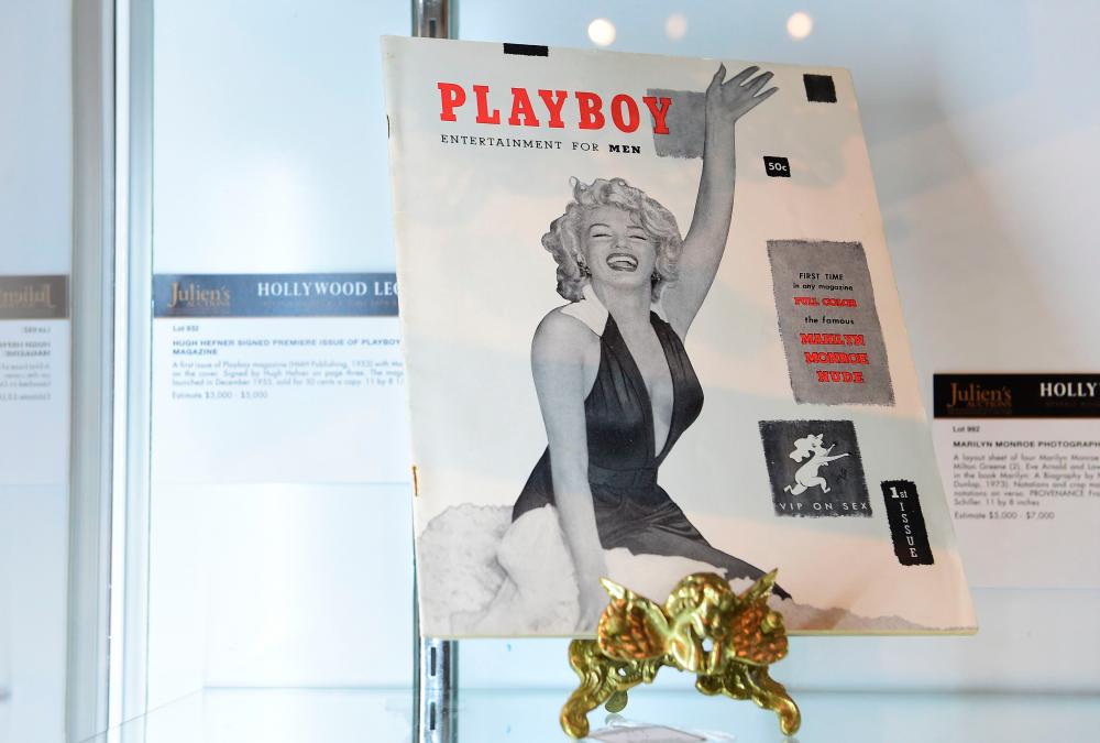 (FILES) In this file photo taken on June 22, 2015 The first issue of Playboy magazine with Marilyn Monroe on the cover and signed by Hugh Hefner on page three is displayed at Julien’s Auction House in Beverly Hills, California ahead of Julien’s “Hollywood Legends Auction”. / AFP / Frederic J. BROWN