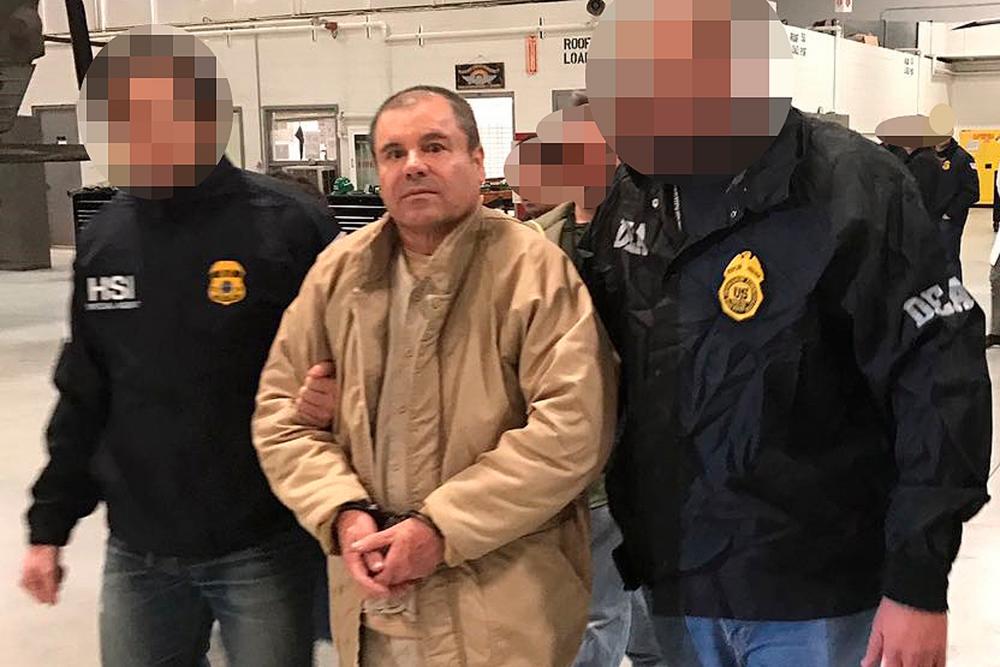 This handout picture released by the Mexican Interior Ministry on January 19, 2017 shows Joaquin Guzman Loera aka “El Chapo” Guzman (C) escorted in Ciudad Juarez by the Mexican police as he is extradited to the United States. — AFP