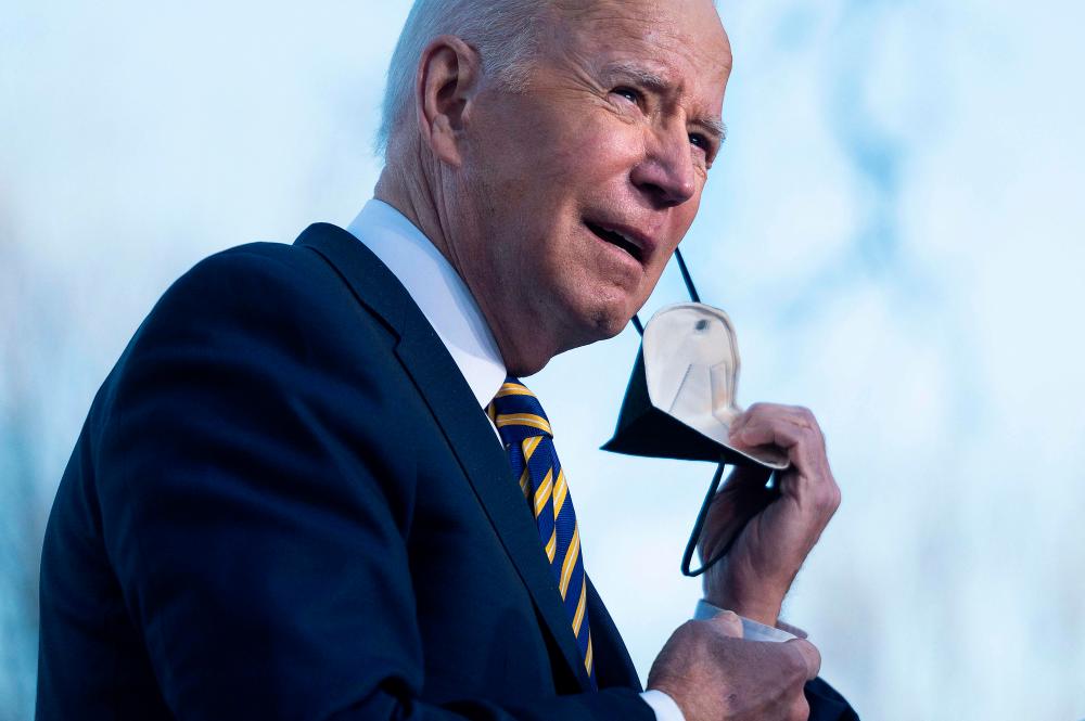 Photo taken on January 11, 2022 President Joe Biden removes a protective mask before speaking about the constitutional right to vote at the Atlanta University Center Consortium in Atlanta, Georgia. AFPPIX