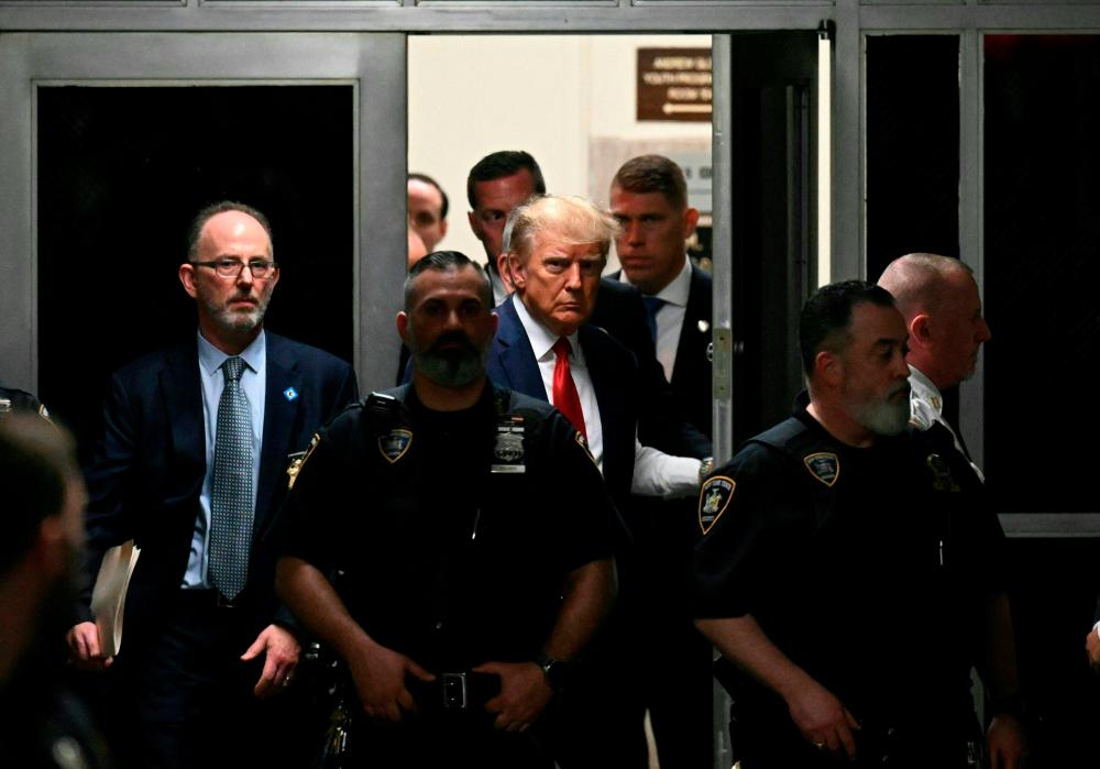 (FILES) In this file photo taken on April 04, 2023, former US President Donald Trump makes his way inside the Manhattan Criminal Courthouse in New York. The US attorney prosecuting Donald Trump sued a Republican lawmaker on April 11, 2023, to try to stop the congressman from interfering in his case against the former president. AFPPIX