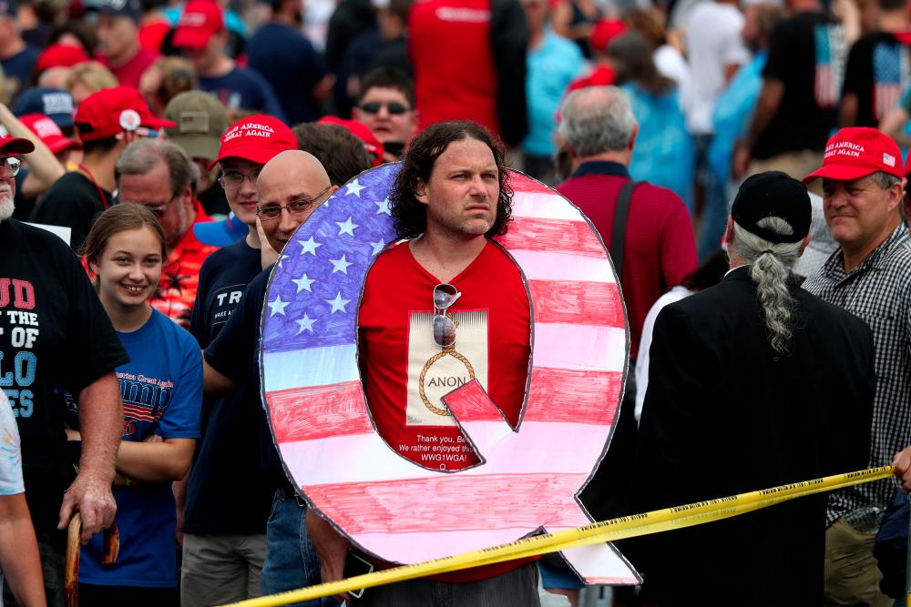 (FILES) In this file photo taken on August 2, 2018 David Reinert holds a large Q sign while waiting in line on to see President Donald J. Trump at his rally at the Mohegan Sun Arena at Casey Plaza in Wilkes-Barre, Pennsylvania. - AFPPIX