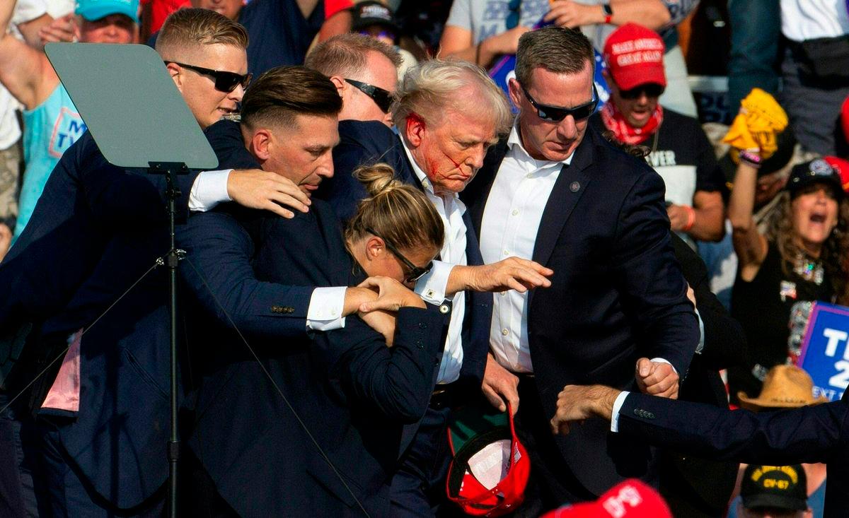 FILEpi - Donald Trump is seen with blood on his face surrounded by secret service agents at a campaign event at Pennsylvania - AFP