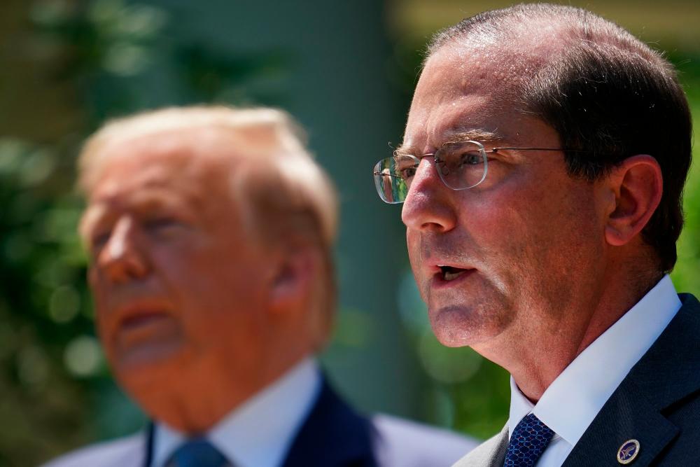 This file photo taken on May 15, 2020 shows US Secretary of Health and Human Services Alex Azar (R) speaking in the Rose Garden of the White House in Washington, DC as US President Donald Trump (L) looks on. — AFP