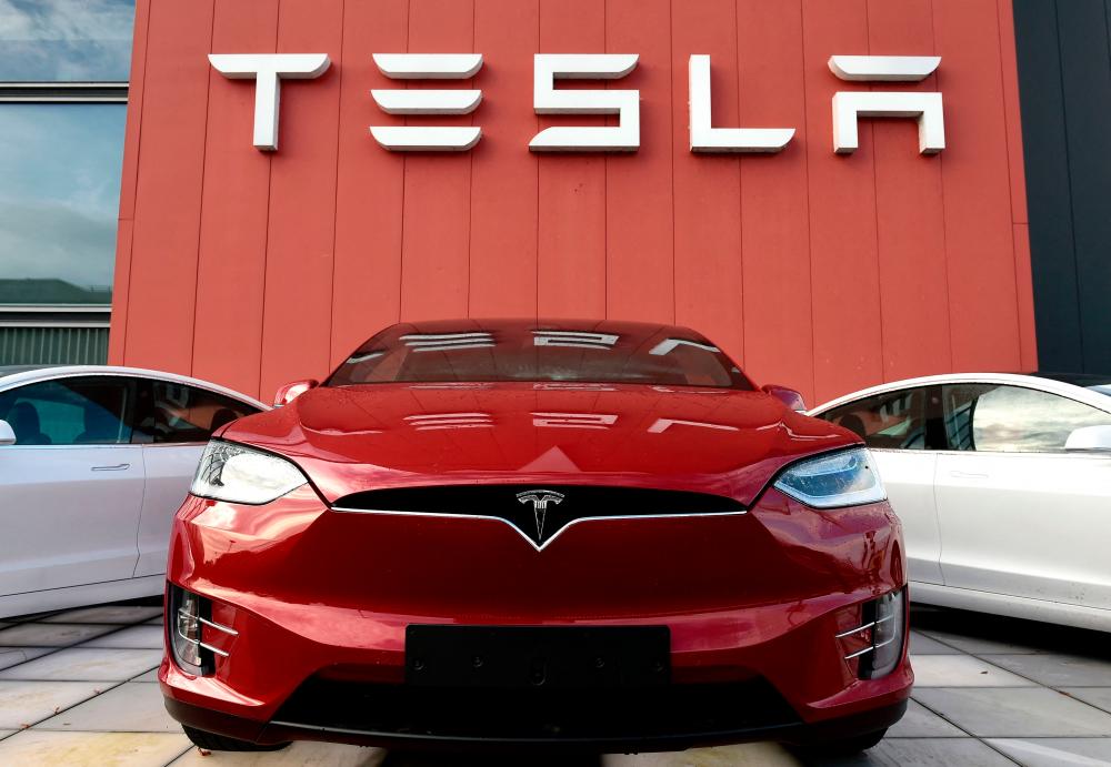 (FILES) In this file photo taken on October 23, 2019 the logo marks the showroom and service center for the US automotive and energy company Tesla in Amsterdam. Six women on December 14, 2021 sued Tesla, alleging a culture of sexual harassment at the electric carmaker's California plant and other facilities that included unwanted touching, catcalls and retaliation for those who complained. AFPPIX