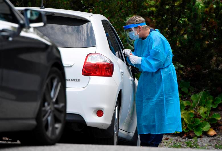 A medical worker wearing a protective suit and a mask takes a swab sample for a coronavirus disease (Covid-19) test at a drive-through testing station in Salo, Finland August 18, 2020. Lehtikuva/Jussi Nukari — Reuters