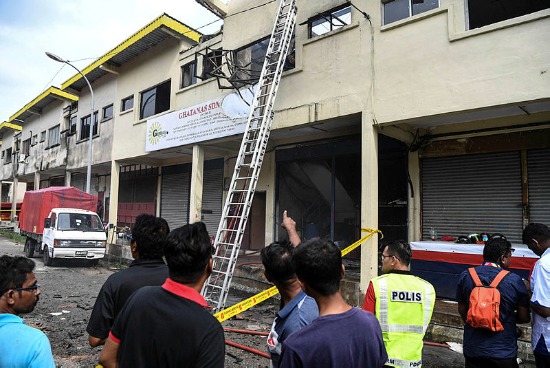 Onlookers outside the two-storey shophouse following a fire this afternoon.