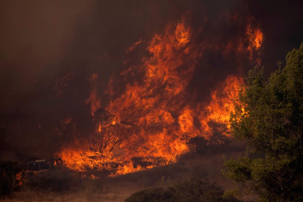 A firefighting bulldozer battles the Bond Fire wildfire near Lake Irvine in Orange County, California, U.S., December 3, 2020. — Reuters