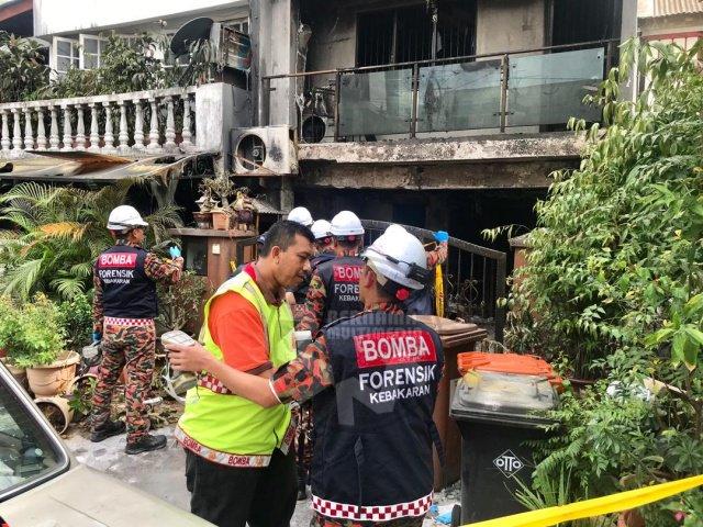 Officers from the Fire Department’s Forensic team at the scene of the house fire that claimed three lives earlier this morning at Kampung Lindungan, Petaling Jaya. – Bernama