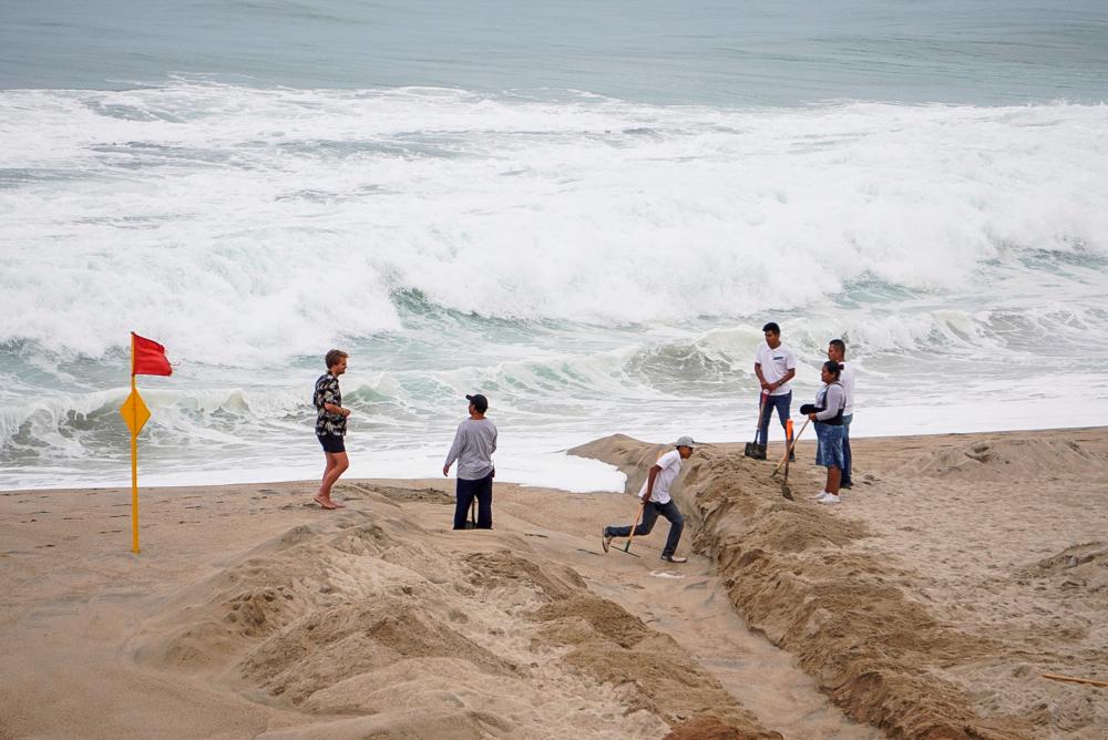 People chat with men working on the beach as Hurricane Agatha barrels toward the southern coast of Mexico, in Puerto Escondido, Oaxaca state, Mexico, May 29, 2022. REUTERSPIX