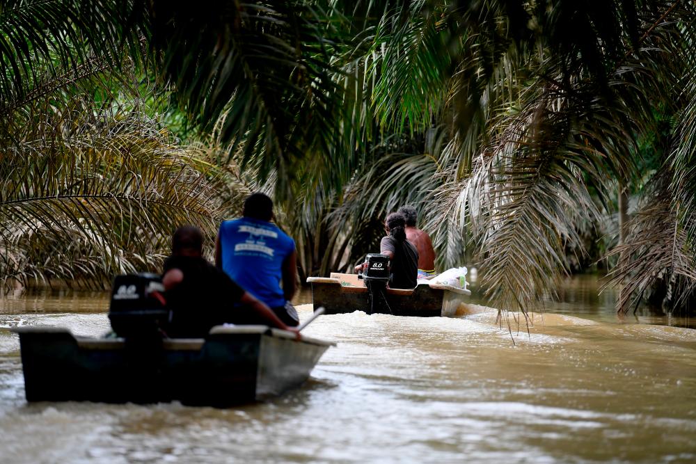 The Orang Asli community of Kampung Kuala Sengka boarded a boat to pick up necessities due to the road that is often used, has been submerged by more than nine feet high around the villages around Kahang today. — Bernama