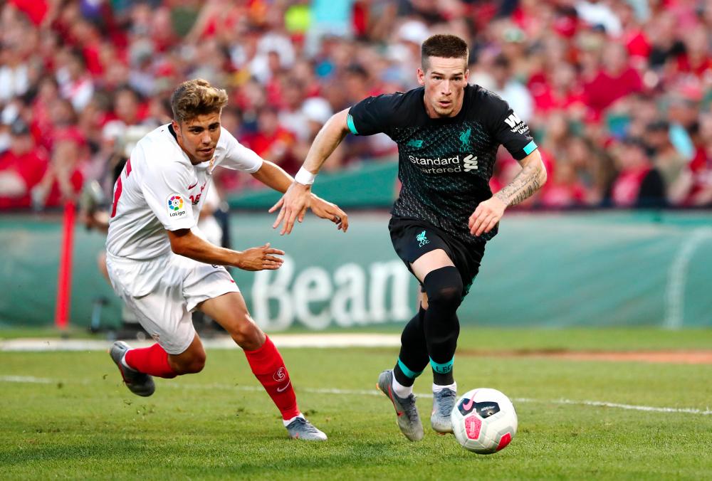 Ryan Kent #40 (R) of Liverpool handles the ball in the second half against Sevilla during a pre-season friendly at Fenway Park on July 21, 2019 in Boston, Massachusetts. — AFP