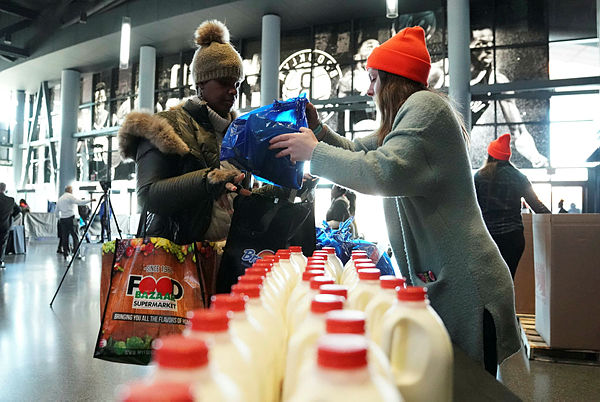 Furloughed federal workers gather bags of food and milk as the Food Bank For NYC holds food distribution for federal workers impacted by the government shutdown in Brooklyn — AFP