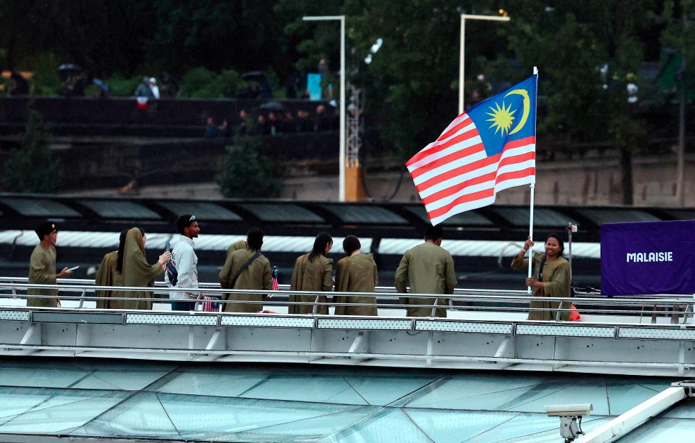Malaysia’s Chef de Mission for the 2024 Paris Olympics, Datuk Hamidin Mohd Amin, along with Malaysia’s (Jalur Gemilang) flag-bearers, diving athlete Betrand Rhodic Lises and sailor Nur Shazrin Mohamad Latif, together with the national contingent’s athletes and officials, boarded a boat during the opening ceremony of the Paris 2024 Olympic Games on the Seine River today. - BERNAMApix