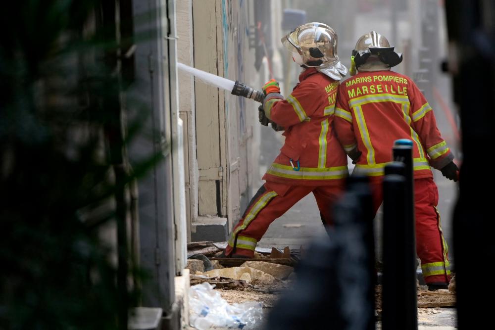 Marseille firefighters spray water with an active water hose as they work in the 'rue Tivoli' after a building collapsed in the same street, in Marseille, southern France, on April 9, 2023. AFPPIX