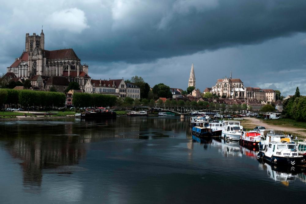 This picture taken in Auxerre on May 13, 2021 shows the river Yonne and the Abbey of Saint-Germain d'Auxerre in the background. –AFP