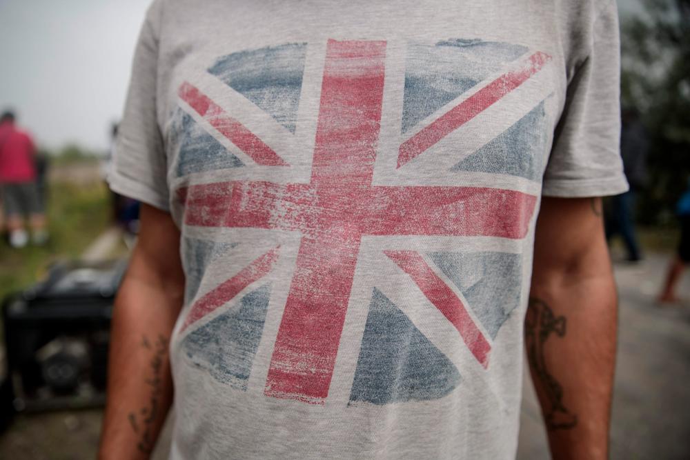 A migrant wears a t-shirt with the British flag at a makeshift camp in the outskirts of Calais, northern France, on Aug 15, 2020. — AFP