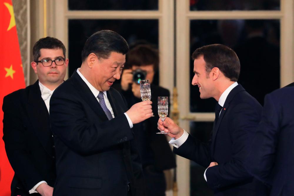 Macron (right) and Xi toast each other during a state dinner at the Elysee Palace in Paris, on March 25, 2019, as part of a Chinese state visit to France - AFPPIX