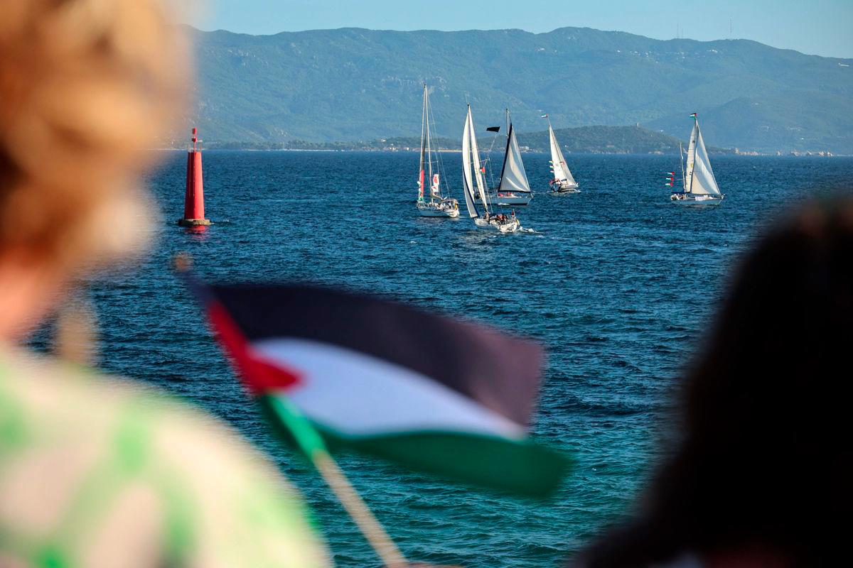 Aktivis melambai bendera Palestin ketika sebuah flotila berlepas membawa bantuan kemanusiaan dan aktivis yang berikrar untuk cuba “memecahkan kepungan Gaza”, di Ajaccio, di pulau Mediterranean Perancis, Corsica, pada 12 September 2025. - AFP
