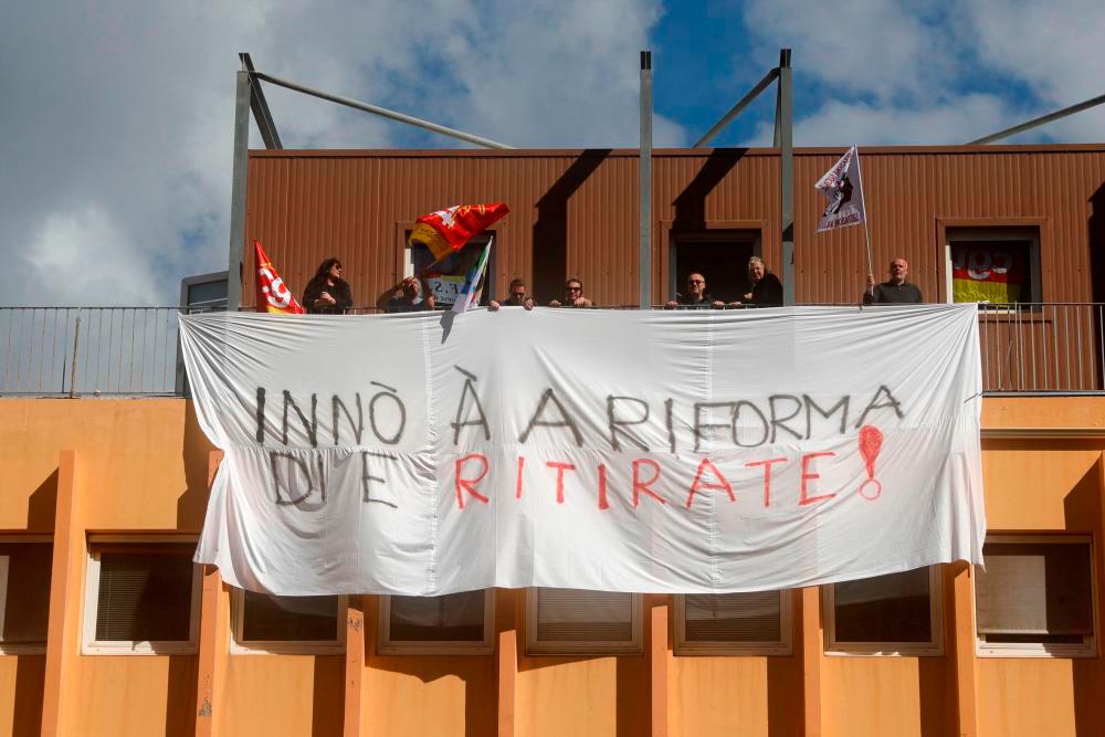 Trade union members stand on the building’s terrace with a banner as they occupy the Ajaccio DREETS (Regional Directorates of Economy, Employment, Labour and Solidarity) in protest of the French government’s pensions reform bill, in Ajaccio, on the French Mediterranean island of Corsica, on March 4, 2023/AFPPix