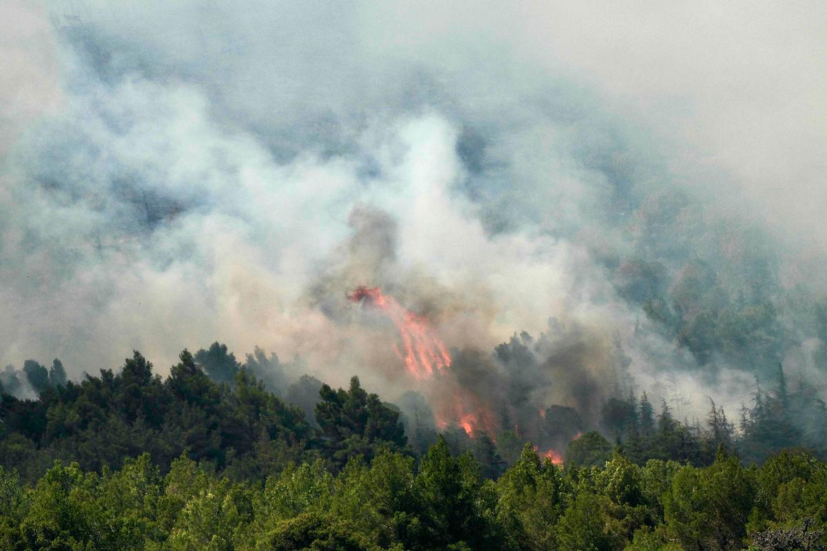 A new fire rages in a forest near the city of Narbonne, southwestern France, on July 8, 2025. (Photo by IDRISS BIGOU-GILLES / AFP)