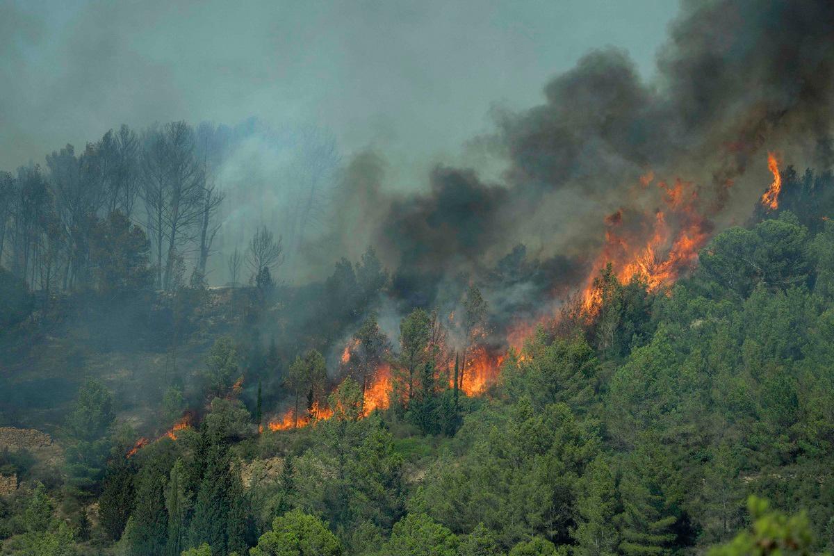 Smoke billows from a forest fire in Lagrasse, southwestern France, on August 5, 2025. A fire that broke out on August 5, 2025 afternoon in Ribaute (Aude) had already spread across 1,000 hectares by early evening, according to the prefecture, prompting the evacuation of at least one campsite and several homes, an AFP journalist reported. - IDRISS BIGOU-GILLES / AFP