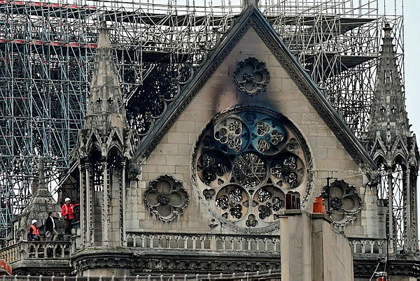 Inspectors are seen on the roof of the landmark Notre-Dame Cathedral in central Paris on April 16, 2019, the day after a fire ripped through its main roof. — AFP