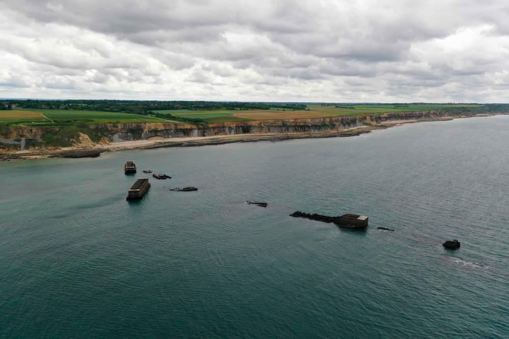 An aerial view of the hollow concrete blocks, the remains of Mulberry harbour which comprised of floating roadways and pier heads that went up and down with the tide, pictured in Arromanches-les-Bains, northwestern France on May 30, 2019. - AFP