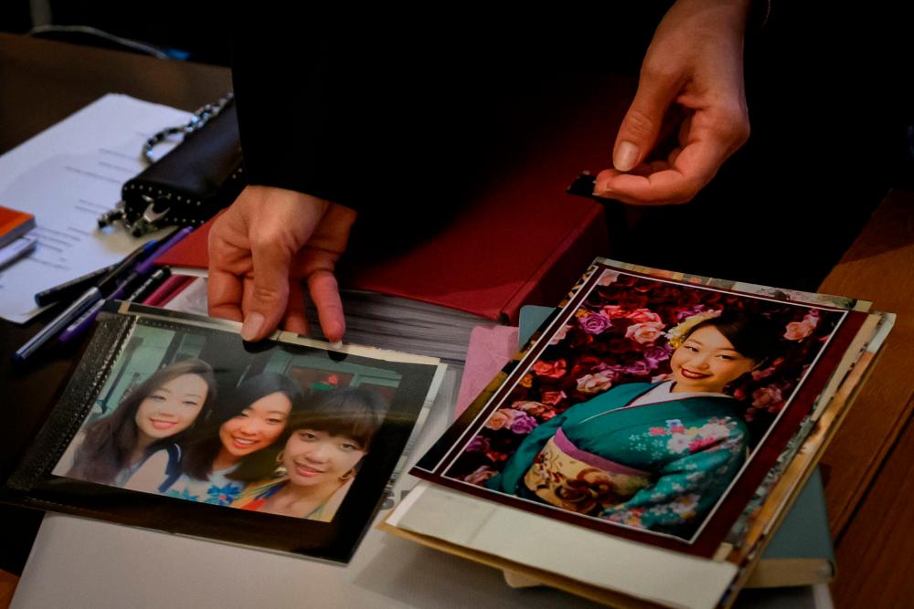 Sylvie Galley, the lawyer of the family of murdered Japanese student Narumi Kurosaki, holds some pictures of Narumi Kurosaki, on the first day of the appeal trial of Nicolas Zepeda, a Chilean man accused of allegedly murdering his Japanese ex-girlfriend in France in 2016, in Vesoul, eastern France, on December 4, 2023/AFPPix