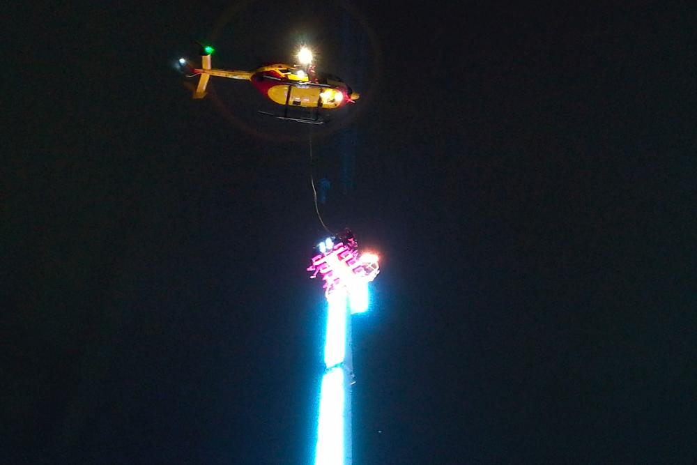A helicopter hovers over a giant funfair ride after eight people got stuck high in the air in the Brittany city of Rennes late on Dec 31, 2018. — AFP