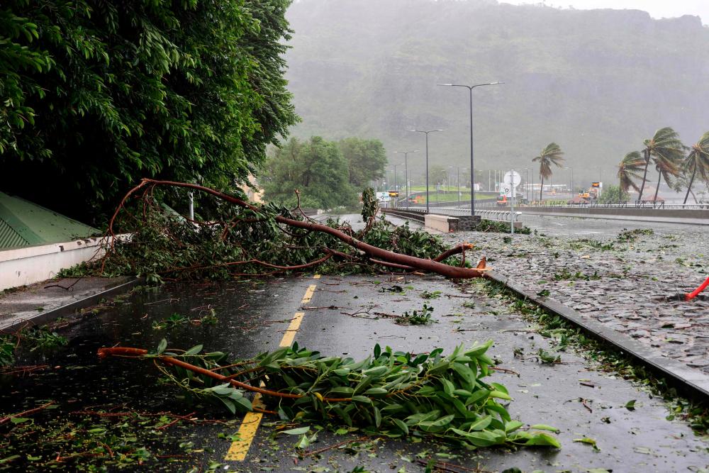 Tree branches block the road with the passage of tropical cyclone Batsirai on the north of the French Indian Ocean island of La Reunion in Saint-Denis de la Reunion on February 3, 2022, as the island was placed under a cyclonic red alert, forcing the 860,000 inhabitants to barricade themselves. AFPPIX