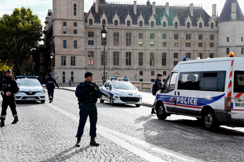 Police officers stand guard near Paris prefecture de police (police headquarters) on Oct 3, 2019 after four officers were killed in a knife attack. — AFP