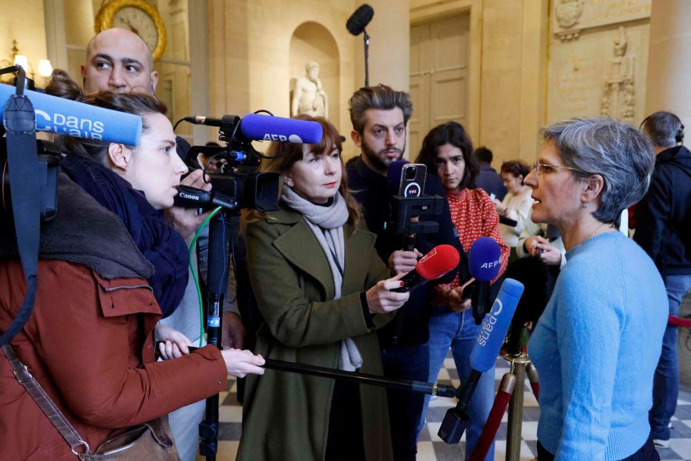 EELV member of the parliament Sandrine Rousseau (R) answers journalists’ questions on the sidelines of a debate on the draft law to control immigration at the French National Assembly in Paris on December 19, 2023/AFPPix