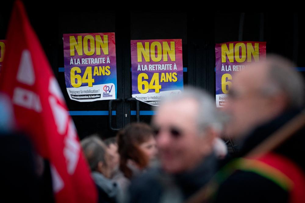 Protesters gather as placards reading “No to retirement at 64” are seen during a demonstration two days after the French government pushed a pensions reform through parliament without a vote, using the article 49.3 of the constitution, in Le Havre, northwestern France, on March 18, 2023. AFPPIX