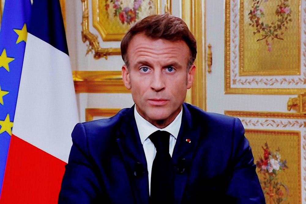 A photograph of a television screen shows French President Emmanuel Macron during a televised address to the nation on the topic of conflict between Israel and Palestinian militant group Hamas, made from the Elysee Palace, in Paris, on October 12, 2023. AFPPIX
