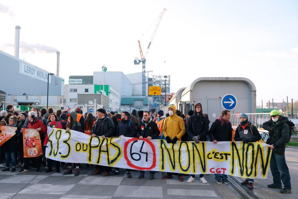 Demonstrators of French General Confederation of Labour (CGT) trade union, holding a banner reading “49.3 or not, 64 No it’s No”, block the entrance of the waste incinerator of Ivry-sur-Seine on April 13, 2023, on the 12th day of action after the government pushed a pensions reform through parliament without a vote, using the article 49.3 of the constitution. AFPPIX