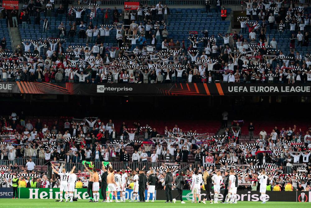 Supporters cheer as Eintracht Frankfurt's players celebrate at the end of the Europa League quarter final second leg football match between FC Barcelona and Eintracht Frankfurt at the Camp Nou stadium in Barcelona on April 14, 2022. AFPpix