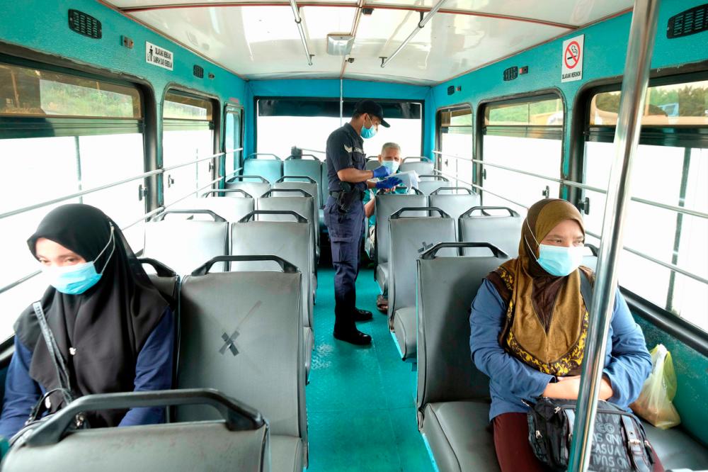 A policeman checking the travel documents of bus passengers in Sandakan on Jan 23 - --fotoBERNAMA (2021) Copyrights Reserved.