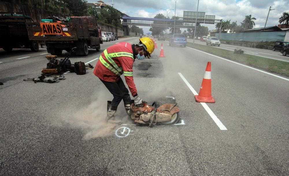Works Department employee is seen resurfacing potholes around Johor Bahru area on Jan 24--fotoBERNAMA (2021) COPYRIGHT RESERVED
